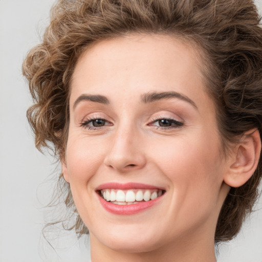 Joyful white young-adult female with medium  brown hair and green eyes