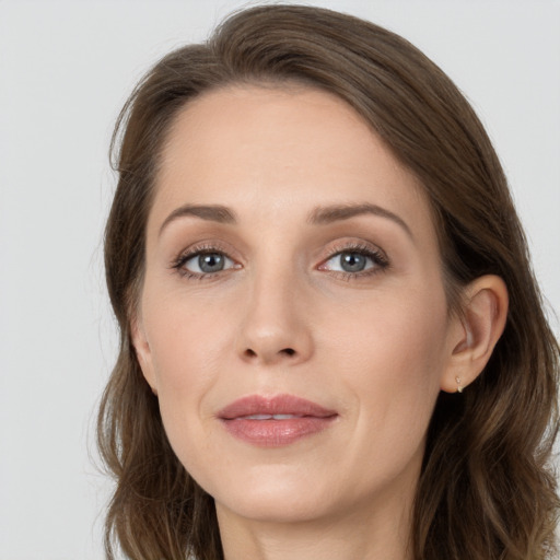 Joyful white young-adult female with long  brown hair and grey eyes