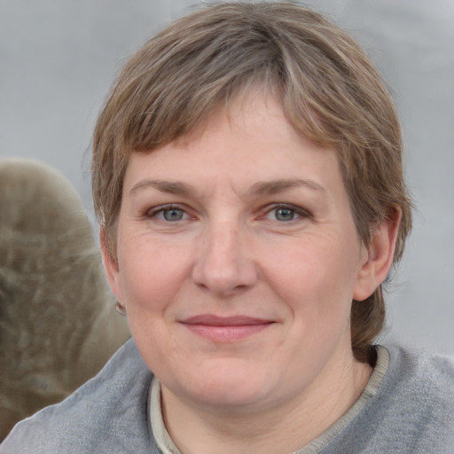 Joyful white young-adult female with medium  brown hair and blue eyes