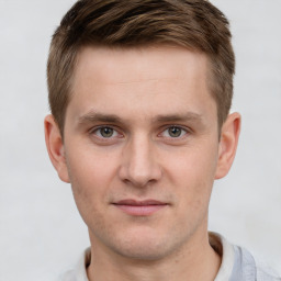 Joyful white young-adult male with short  brown hair and grey eyes