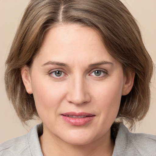 Joyful white young-adult female with medium  brown hair and grey eyes