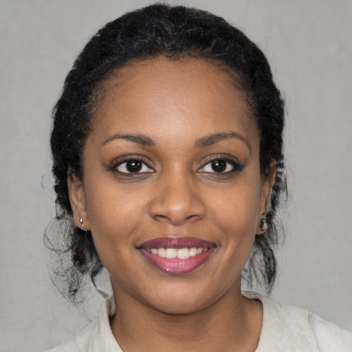 Joyful black young-adult female with medium  black hair and brown eyes