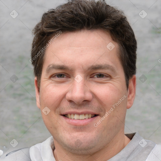 Joyful white adult male with short  brown hair and grey eyes