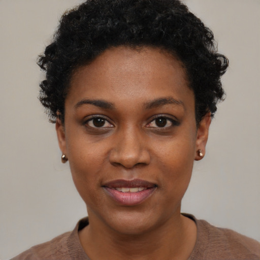 Joyful black young-adult female with short  black hair and brown eyes