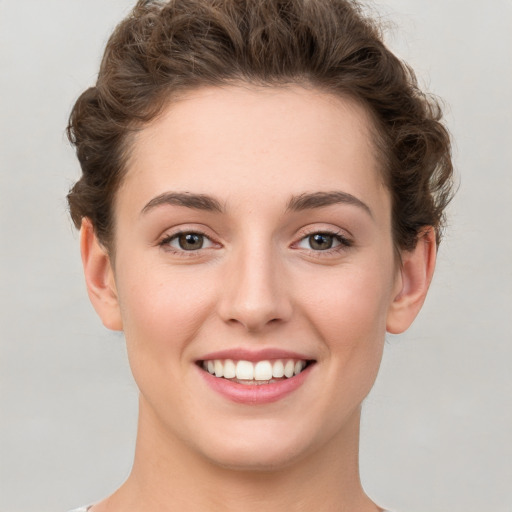 Joyful white young-adult female with short  brown hair and green eyes