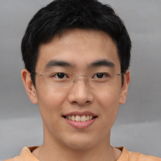 Joyful asian young-adult male with short  brown hair and brown eyes