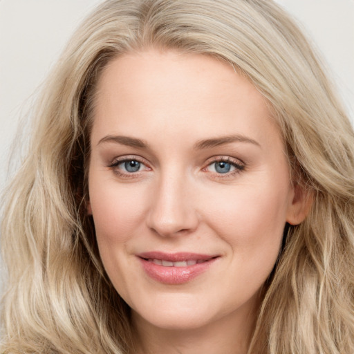 Joyful white young-adult female with long  brown hair and blue eyes