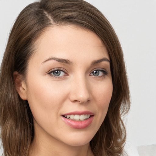 Joyful white young-adult female with long  brown hair and blue eyes