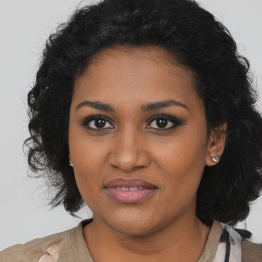 Joyful black young-adult female with long  black hair and brown eyes