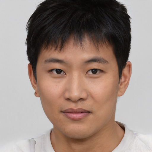 Joyful asian young-adult male with short  brown hair and brown eyes