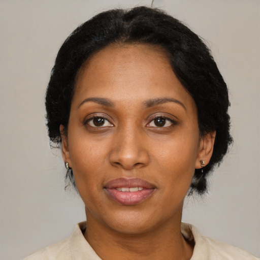 Joyful black adult female with short  black hair and brown eyes