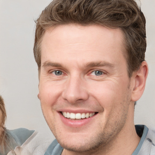 Joyful white adult male with short  brown hair and grey eyes