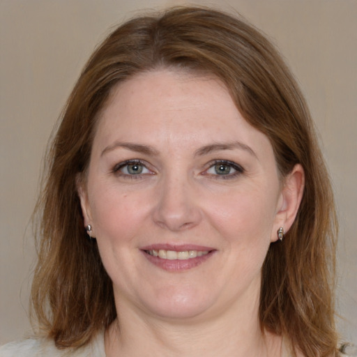 Joyful white adult female with medium  brown hair and grey eyes