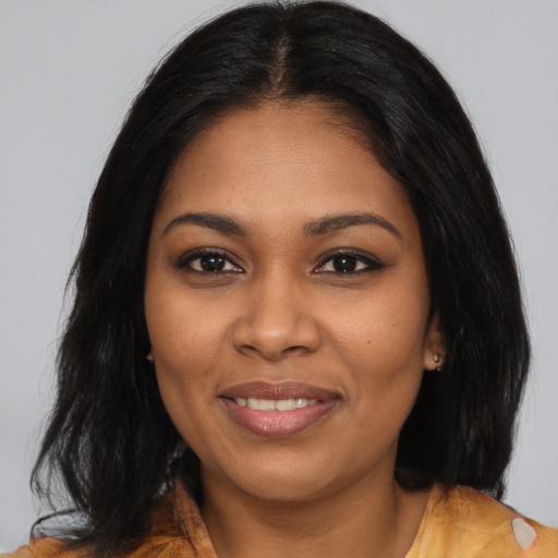 Joyful black young-adult female with long  brown hair and brown eyes