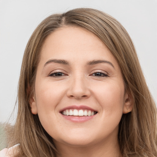 Joyful white young-adult female with long  brown hair and brown eyes