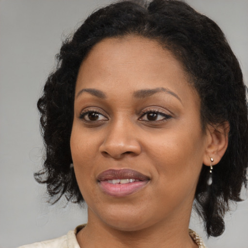 Joyful black young-adult female with medium  brown hair and brown eyes
