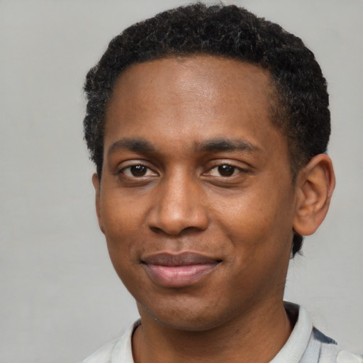 Joyful black young-adult male with short  brown hair and brown eyes