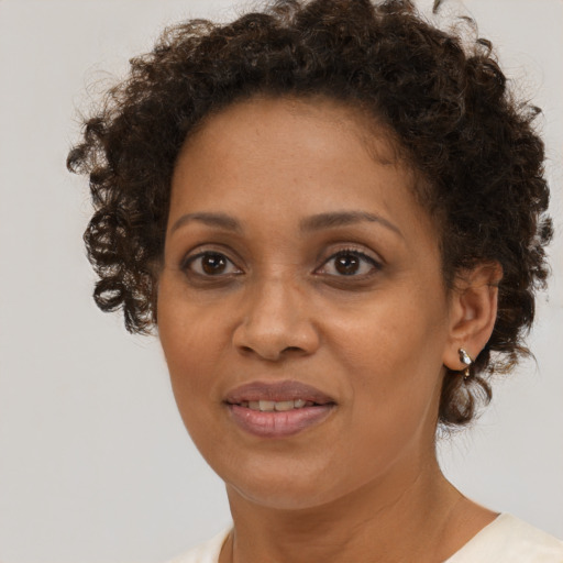 Joyful black adult female with short  brown hair and brown eyes