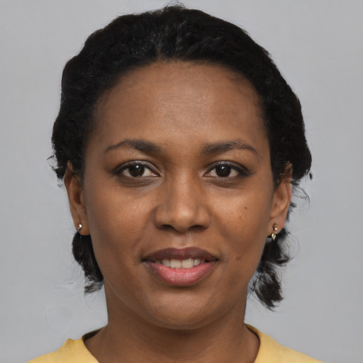 Joyful black young-adult female with short  black hair and brown eyes