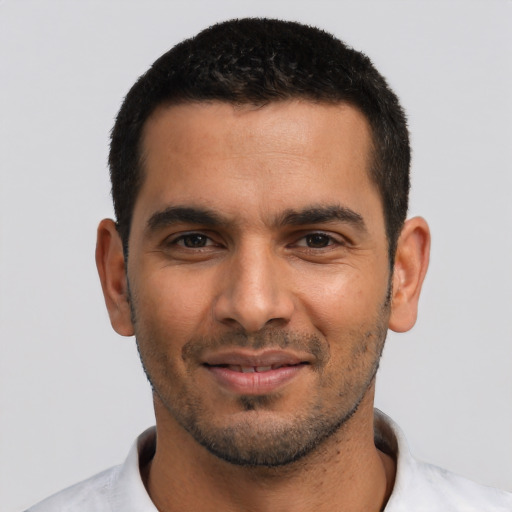 Joyful latino young-adult male with short  black hair and brown eyes