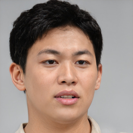 Joyful asian young-adult male with short  brown hair and brown eyes