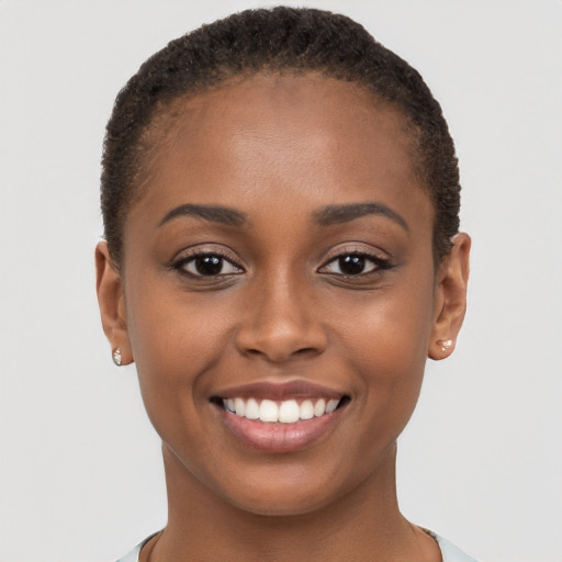 Joyful black young-adult female with short  brown hair and brown eyes