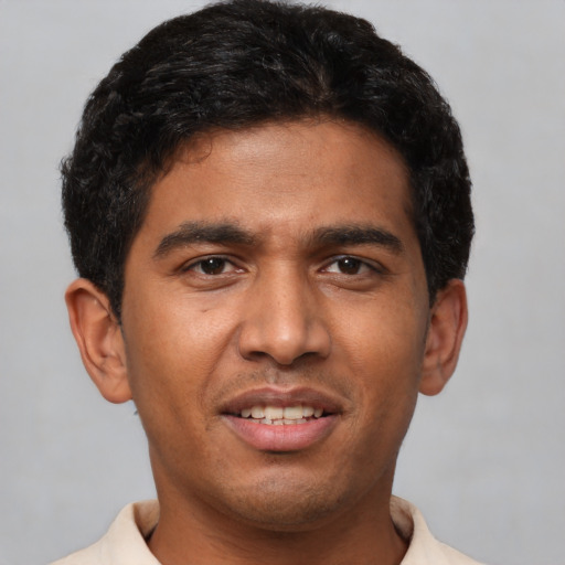 Joyful latino young-adult male with short  black hair and brown eyes