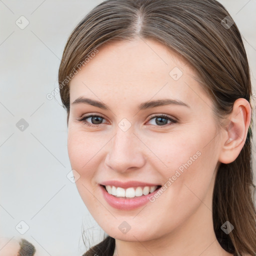 Joyful white young-adult female with long  brown hair and blue eyes