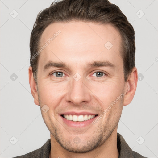 Joyful white young-adult male with short  brown hair and grey eyes