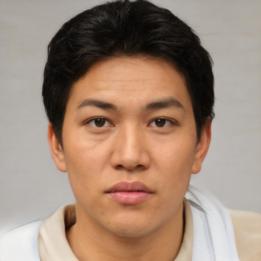 Joyful asian young-adult male with short  brown hair and brown eyes