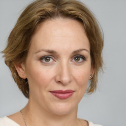 Joyful white adult female with medium  brown hair and green eyes