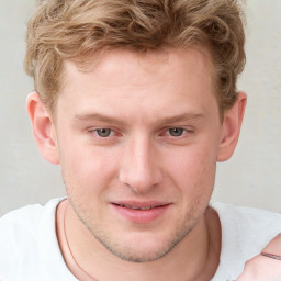 Joyful white young-adult male with short  brown hair and blue eyes