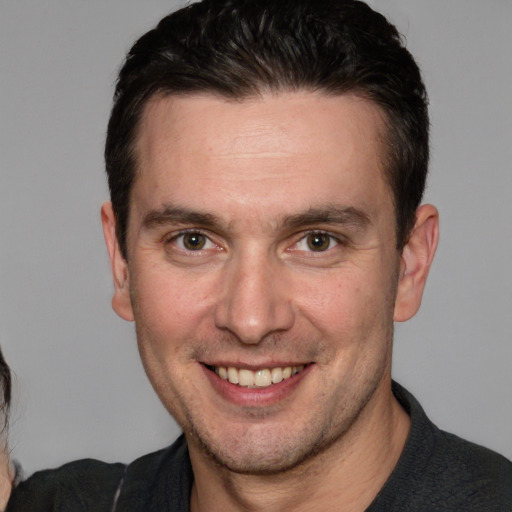 Joyful white adult male with short  brown hair and brown eyes