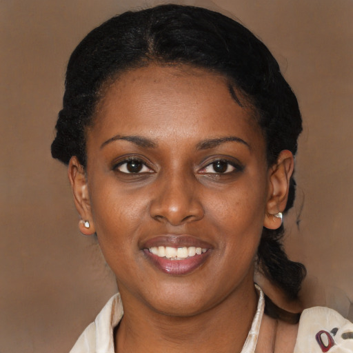 Joyful black young-adult female with short  black hair and brown eyes