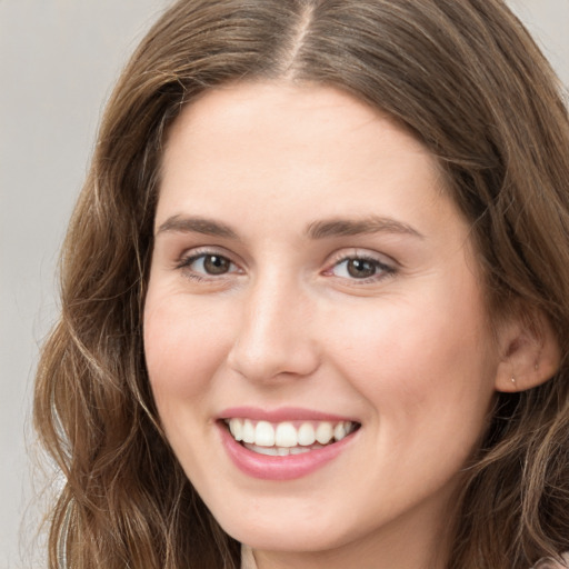 Joyful white young-adult female with long  brown hair and green eyes