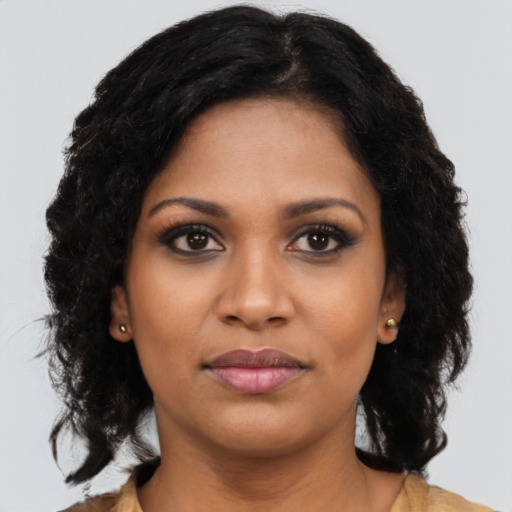 Joyful black young-adult female with long  brown hair and brown eyes