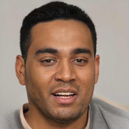 Joyful latino young-adult male with short  black hair and brown eyes