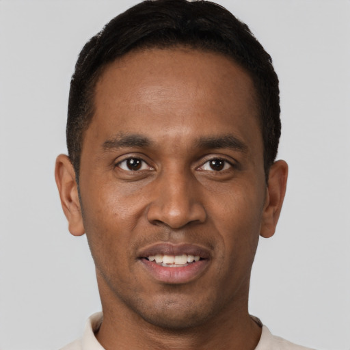 Joyful black young-adult male with short  brown hair and brown eyes