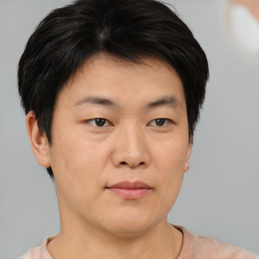 Joyful asian young-adult male with short  brown hair and brown eyes