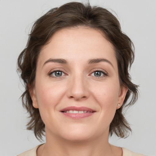 Joyful white young-adult female with medium  brown hair and green eyes