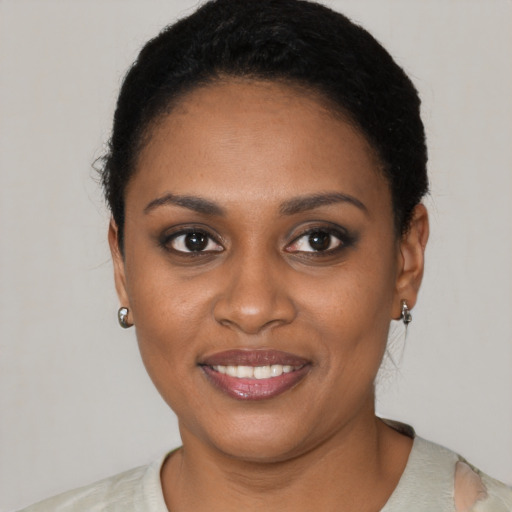 Joyful black young-adult female with short  brown hair and brown eyes
