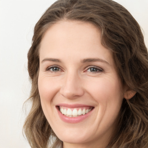 Joyful white young-adult female with long  brown hair and green eyes