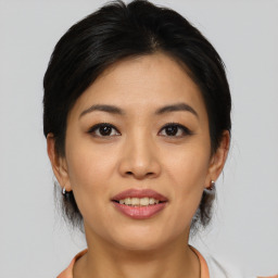 Joyful asian young-adult female with medium  brown hair and brown eyes