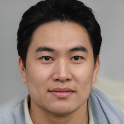 Joyful asian young-adult male with short  brown hair and brown eyes