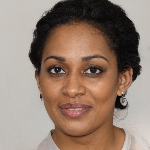 Joyful black adult female with short  black hair and brown eyes