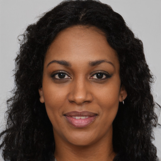 Joyful black young-adult female with long  black hair and brown eyes