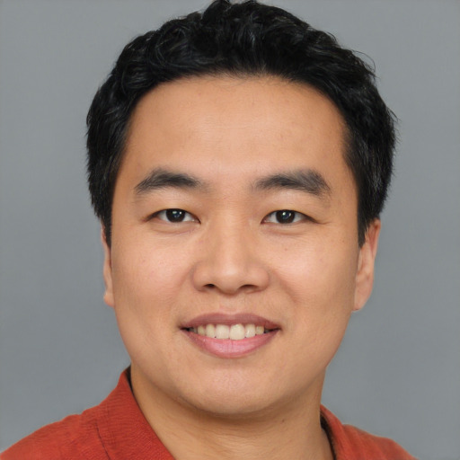 Joyful asian young-adult male with short  black hair and brown eyes