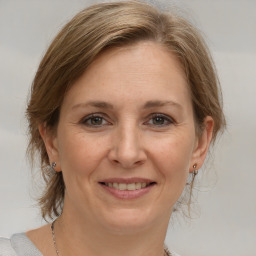 Joyful white adult female with medium  brown hair and brown eyes