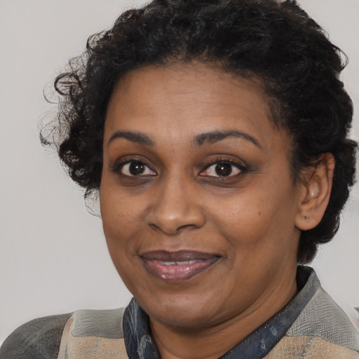 Joyful black adult female with short  black hair and brown eyes