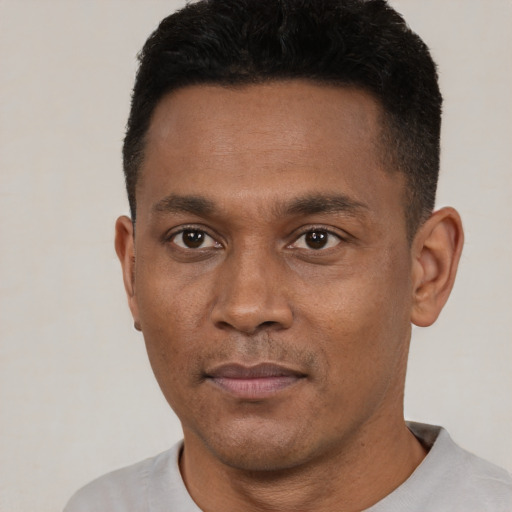 Joyful black young-adult male with short  black hair and brown eyes